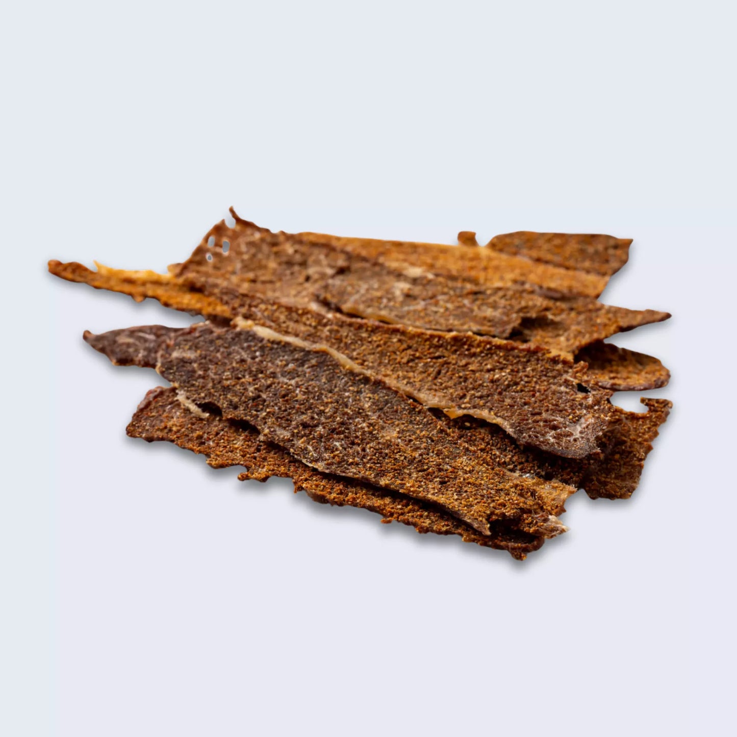 Dried beef jerky strips on a light gray background
