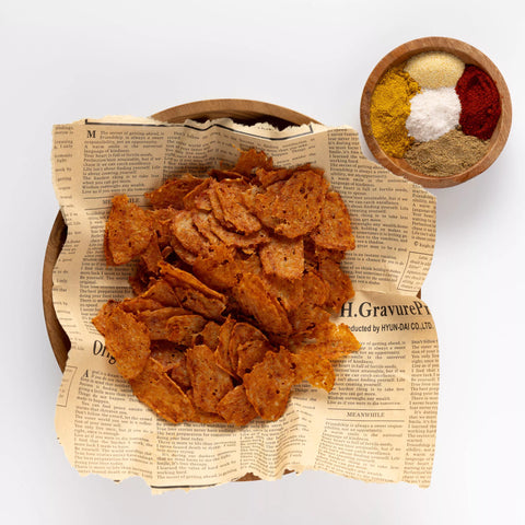 Bowl of cereal with newspaper-textured paper and a small bowl of spices on a white background